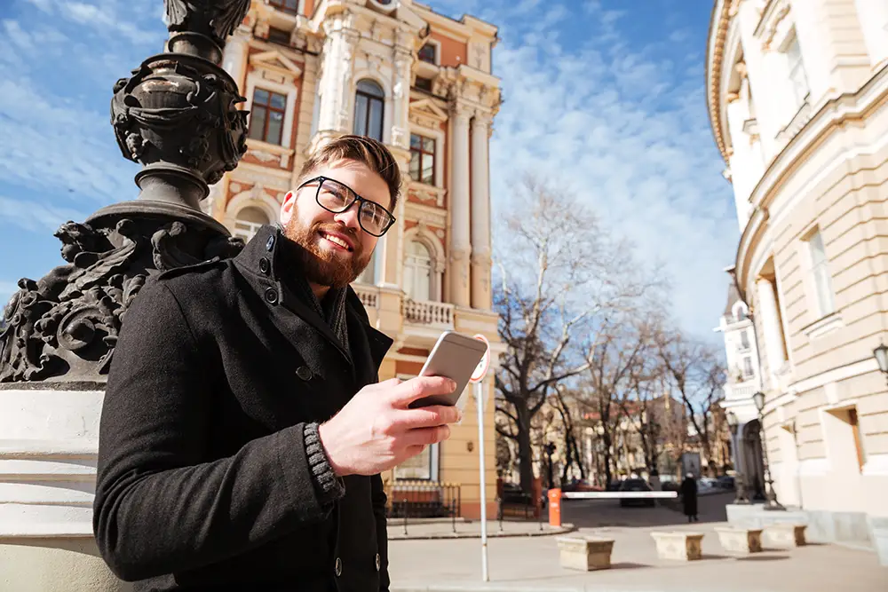 man i frankrike som står med sin telefon